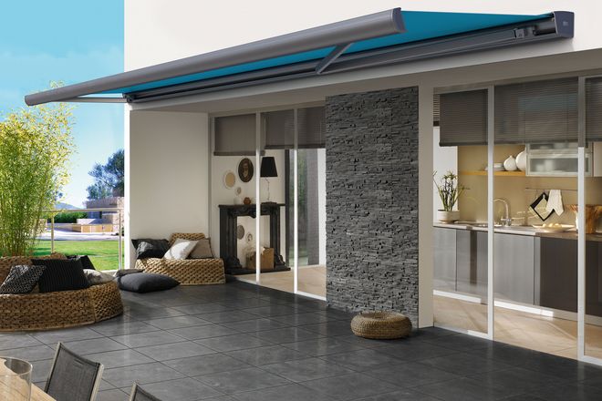 Markisen mit gerundetem Ausfallprofil fügen sich harmonisch in Terrassengestaltungen mit Naturmaterialien und runden Möbeln ein.