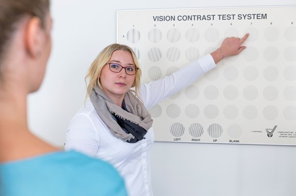 Mit ihren Kunden führen Augenoptiker grundlegende Sehtests durch.