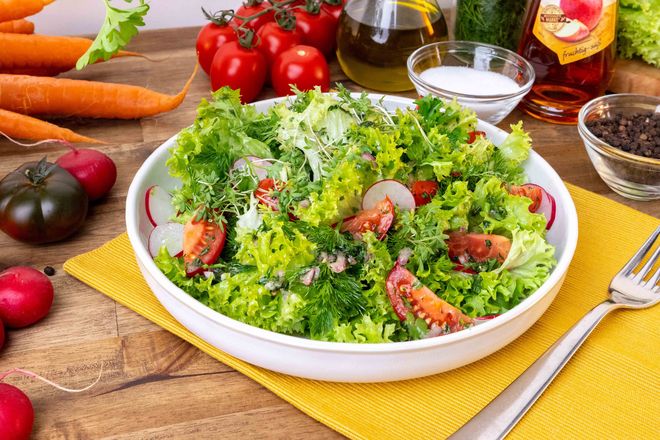 Ein sommerlicher grüner Salat mit Möhrengrün-Dressing passt als frische Beilage zum BBQ.
