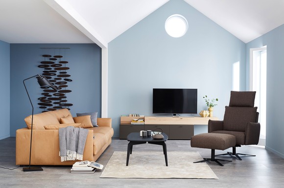Ein Ledersofa mit tiefer Sitzfläche zum Lümmeln, ein drehbarer Relaxer, der immer alles im Blick hat, und ein Lowboard, das den Fernseher trägt und Stauraum bietet: Funktionalität kann schön sein.