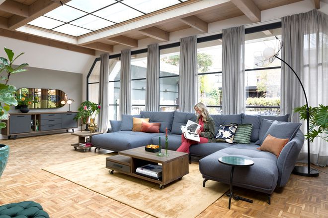 Einfarbige Sofas werden mit bunten Kissen dekoriert.