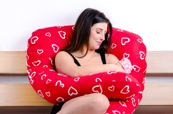 Mit einem Stillkissen kann das Baby in eine bequeme und sichere Stillhaltung gebracht werden.