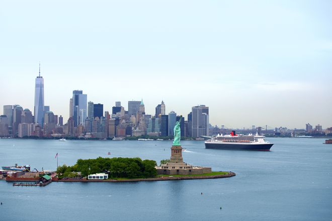 Magisch: Die Queen Mary 2 zwischen der Freiheitsstatue am Eingang zum New Yorker Hafen und der Skyline von Manhattan.