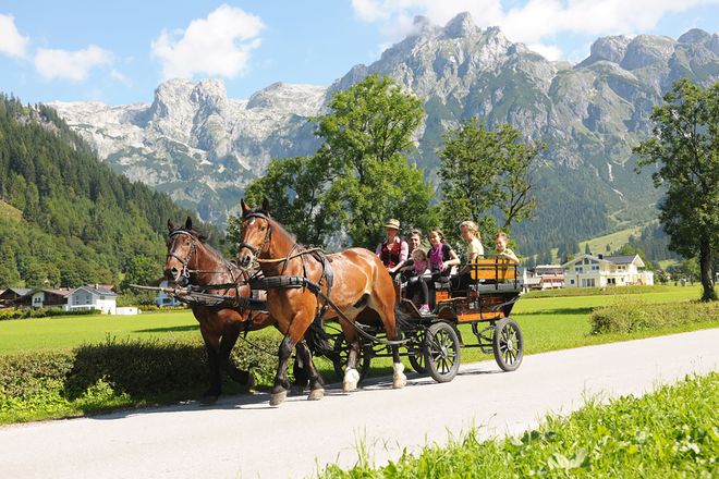 Entspannt: Mit der Pferdekutsche geht es vorbei an sagenhaftem Alpenpanorama.