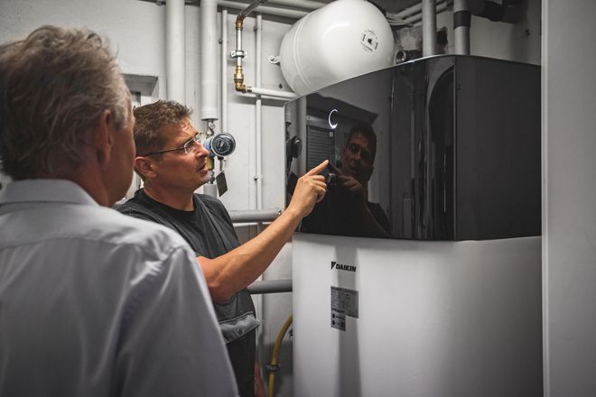 Nach zwei Tagen Montagearbeit erklärt Installateur Oliver Keul (rechts) die Bedienung der Wärmepumpe.