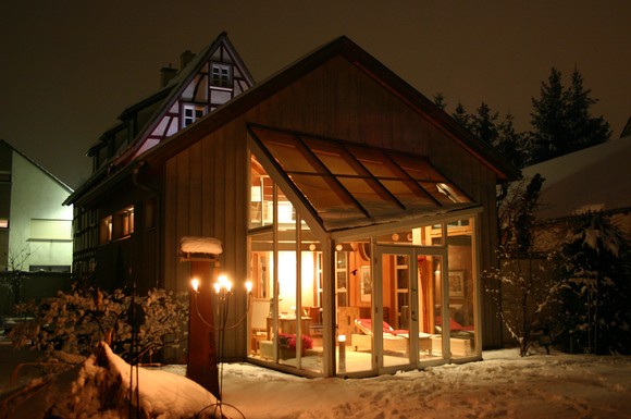 Ist der Garten an einigen markanten Punkten beleuchtet und die Landschaft tief verschneit, befindet man sich im Wintergarten kuschelig warm inmitten eines Winterwunderlandes.