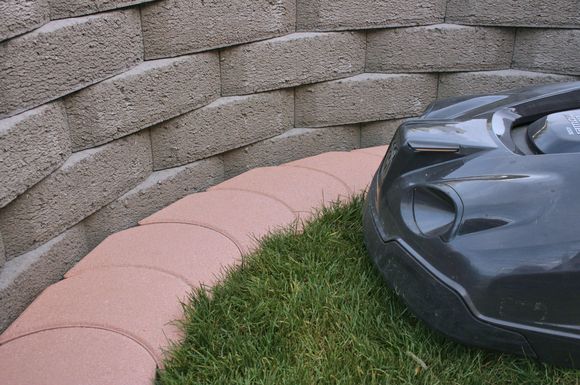 Eine gepflegte Rasenfläche bis in jede Kurve: Mähroboter-Randplatten bilden den sauberen Abschluss für den Rasen.