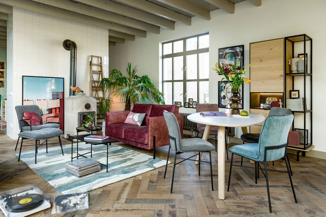 Ein kleiner, runder Tisch und ein hoher Schrank helfen dabei, die Wohnung platzsparend einzurichten.