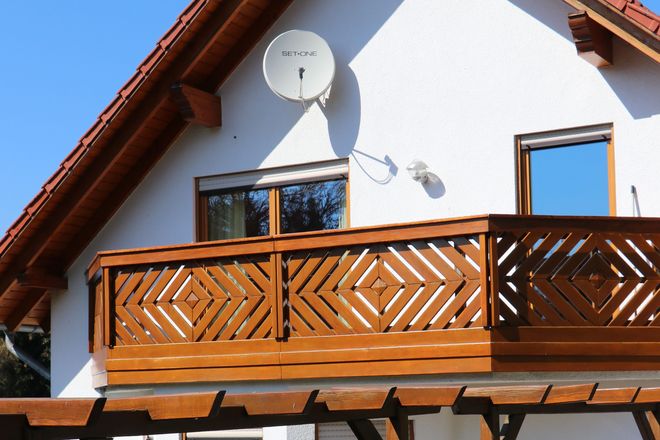 Der angebaute Balkon aus Holz schafft ein zusätzliches Zimmer für die warme Jahreszeit.