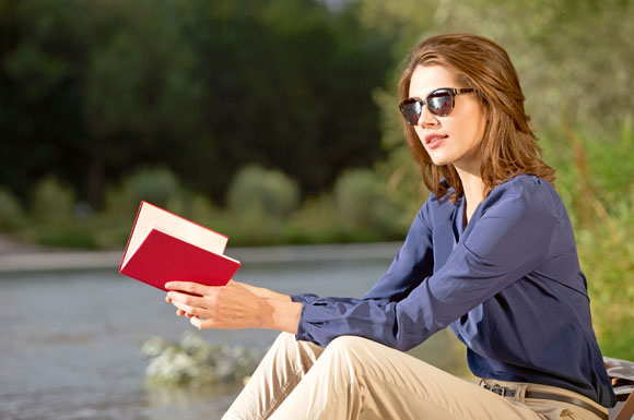 Im Sonnenschein entspannt ein Buch lesen - ohne Sonnenbrille wäre das nicht möglich.