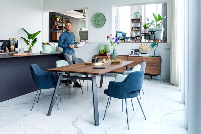 Ein eleganter Stuhl mit Metallbeinen an einem Tisch mit dunkler Platte passt gut ins retro-skandinavische Design.