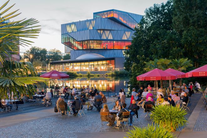 Stimmungsvolles Open-Air-Flair erleben Gäste am Weinpavillon vor spektakulärer Kulisse des Science Centers experimenta an der Neckarbühne in Heilbronn.