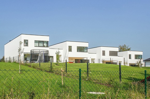 Der Bauhausstil mit seiner kubischen Formensprache liegt im Trend. Dank sehr guter Eigenschaften beim Schallschutz punkten Ziegel auch bei einer Reihenhaus-Bebauung, wie hier in Passau.